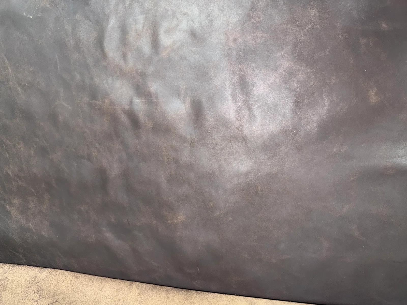 Dark genuine leather material close-up showing surface texture and variation